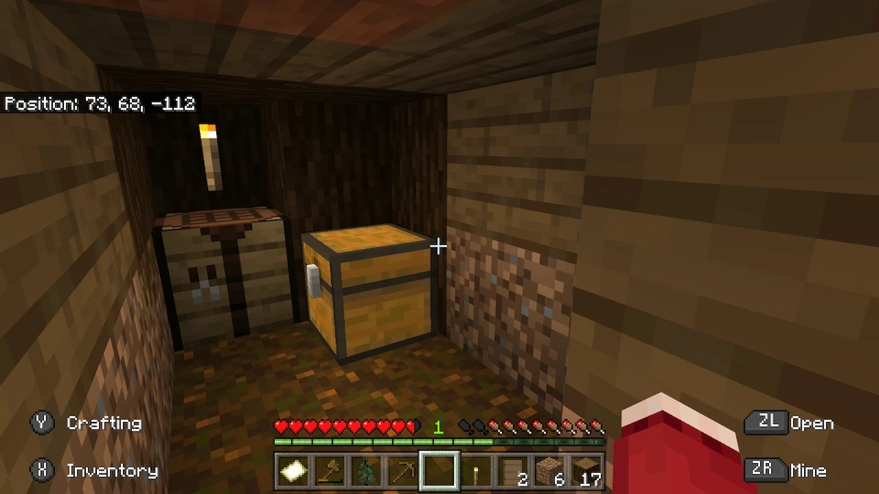 مأوى في Minecraft يحتوي صندوقاً وطاولة صناعة ومشعلاً مع شريط الصحة
