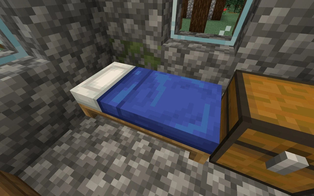 سرير أزرق بجانب صندوق خشبي داخل غرفة حجرية بنافذة في Minecraft